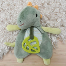 Load image into Gallery viewer, Plush toy dino with a green peace symbol on a textured surface