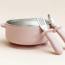 Load image into Gallery viewer, A dusty pink baby feeding bowl with a stainless steel interior and a matching suction base, shown with a pink-handled fork and spoon on a warm beige background. The brand name 'jeaniababy' is embossed on the front of the bowl.